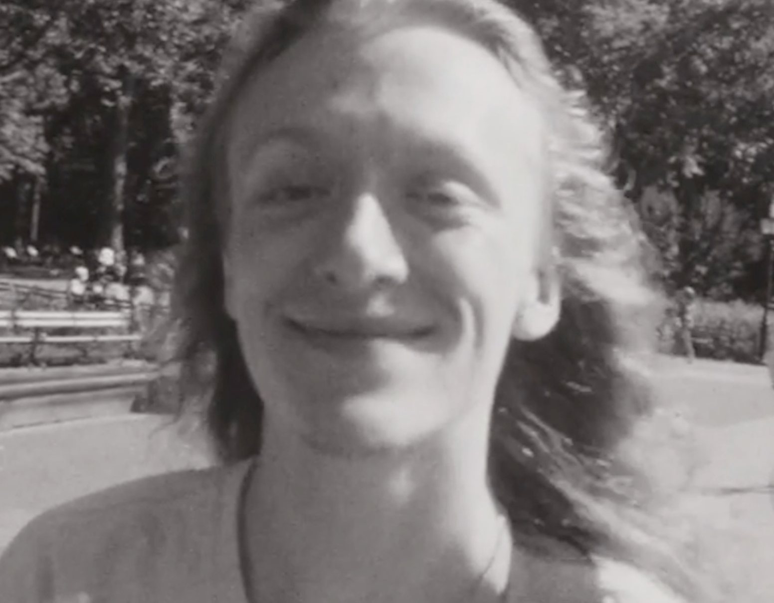 A young man with long hair smiles into the lens.